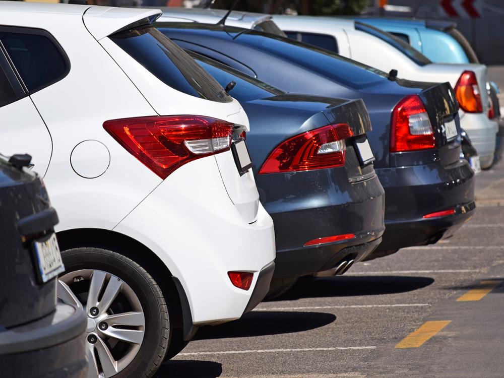 Rear view of parked cars lined up in a parking lot.