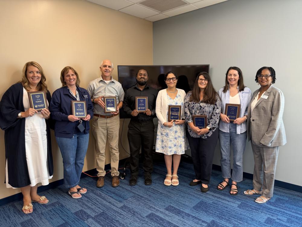 eight people standing next to each other holding plaques
