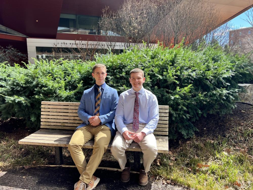 Anakin and Ansel Reinbold, seated on a bench outdoors.