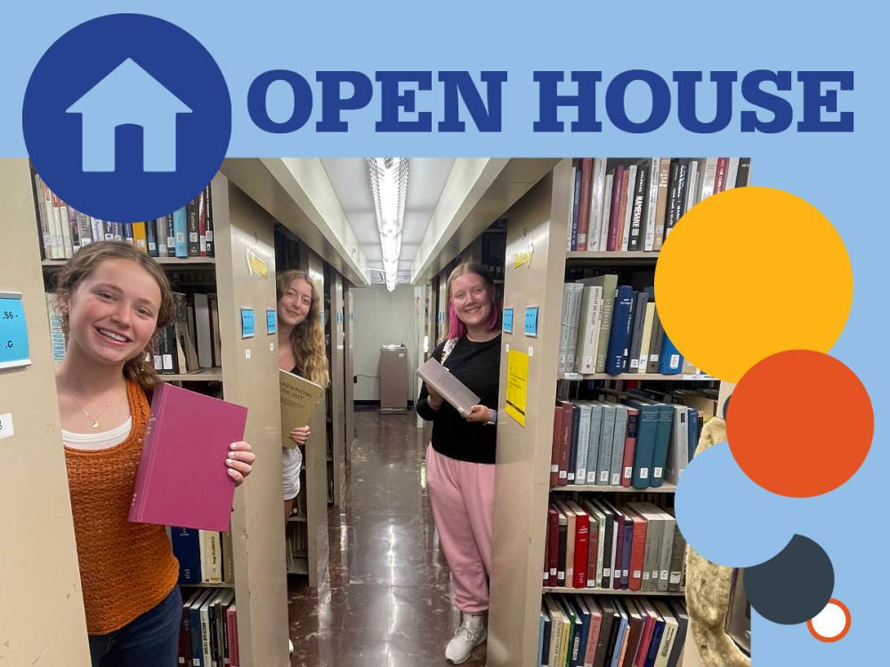 three smiling students stand behind bookshelves in Pattee Libary stacks, holding books