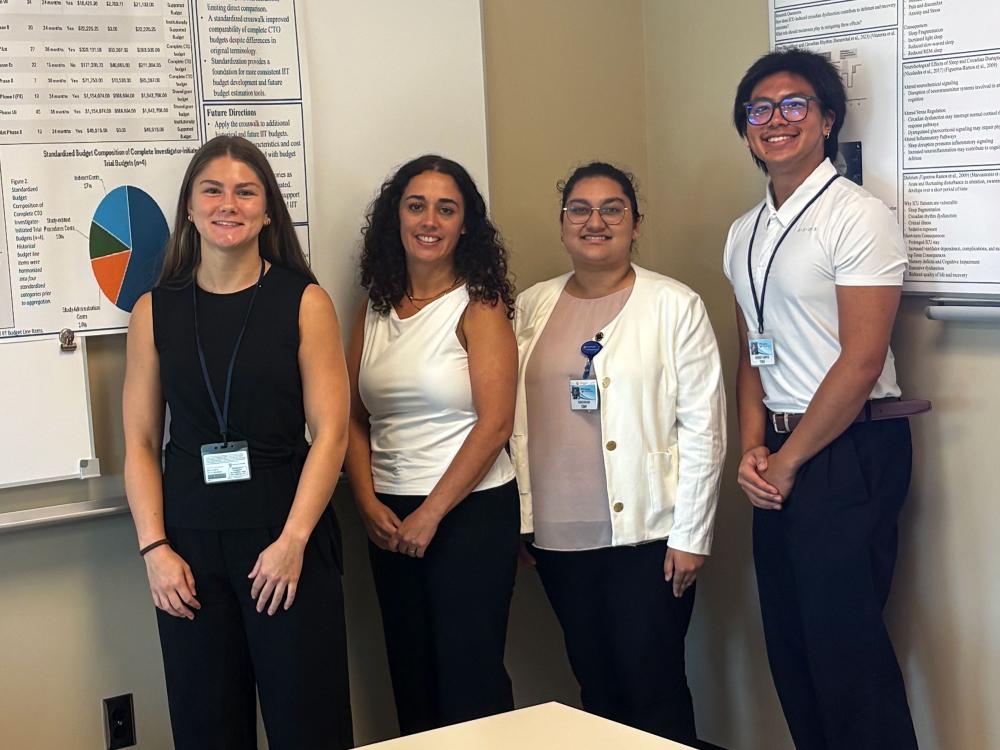 Penn State UCRT interns stand before research presentations at the Penn State College of Medicine.
