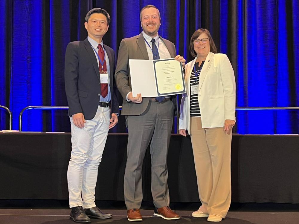 Jared Butler and two ASME award presenters pose for a photo at an ASME awards ceremony.