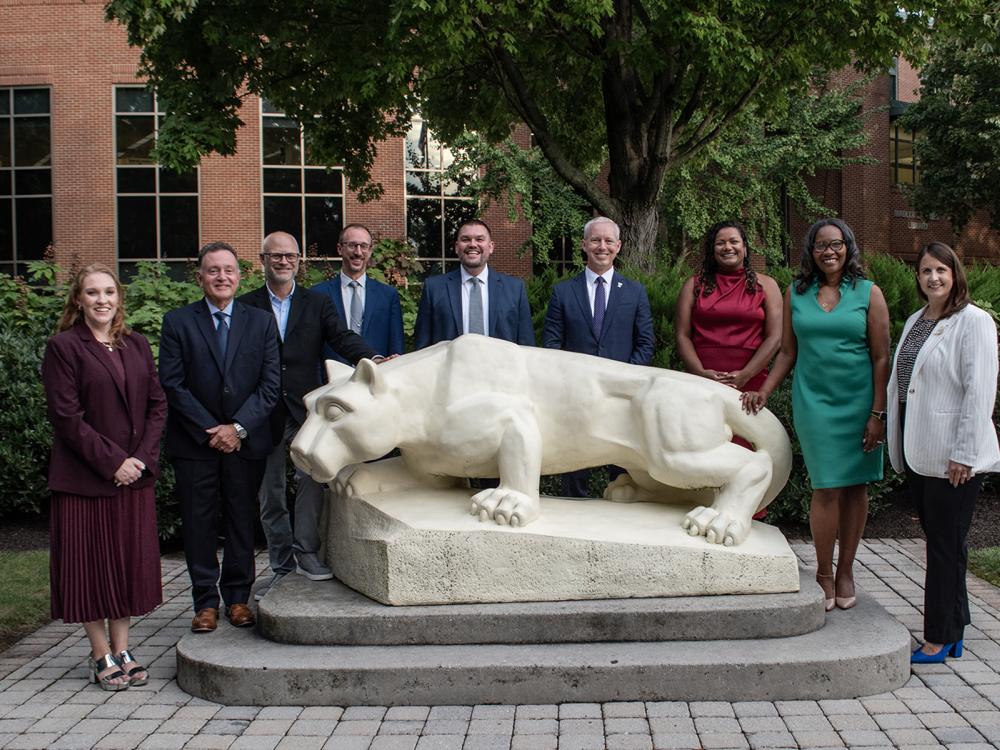 Individuals who received alumni awards gather by the Lion statue at Penn State Harrisburg