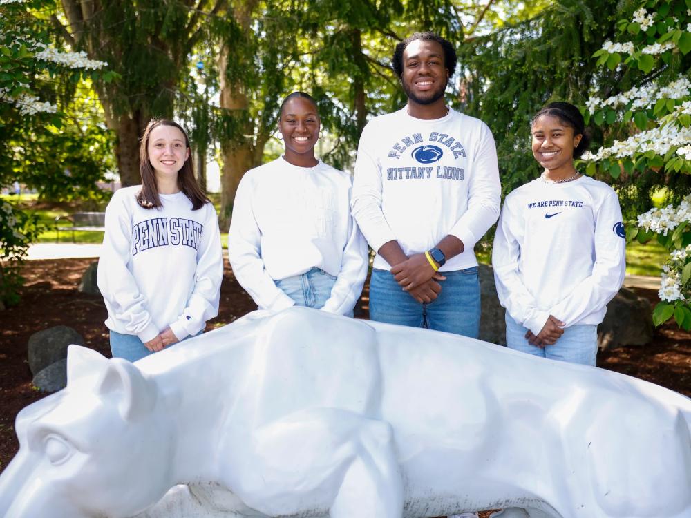 Sara Hallahan, Maddie Ferguson, Tayvon Reid and Tatiana Lewis standing behind the lion shrine