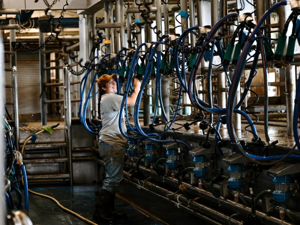 A student works on machinery in a barn