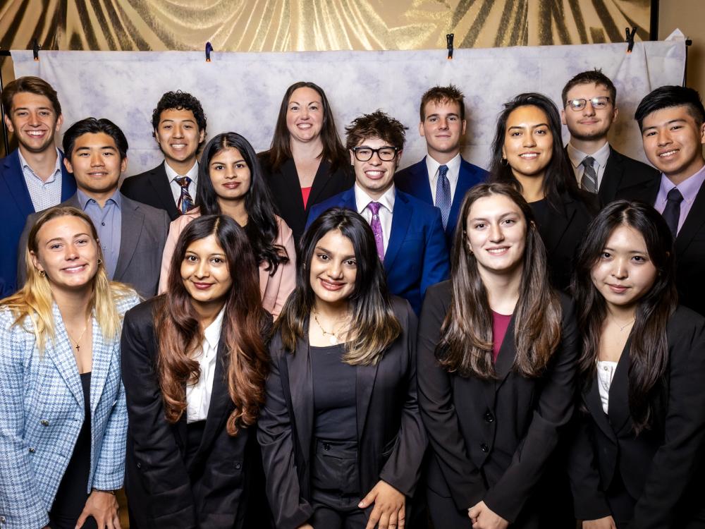A group of students in business attire pose for a group photo