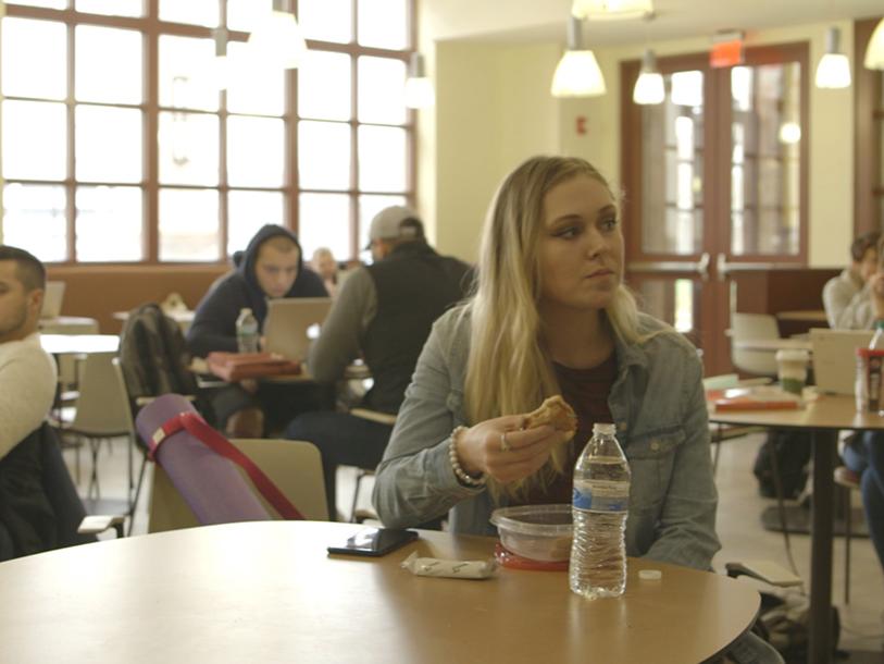 Students in a study space with takeaway containers and water bottles in a still from the film "Hungry to Learn."