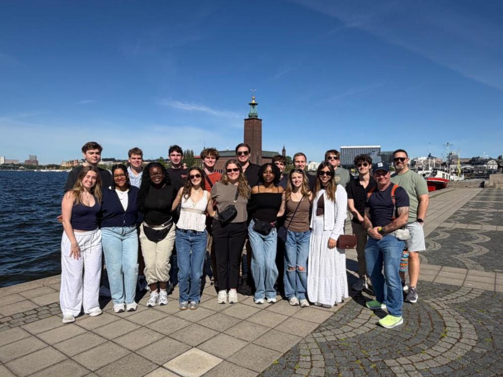 a group of college students pose in front of stockholm city hall