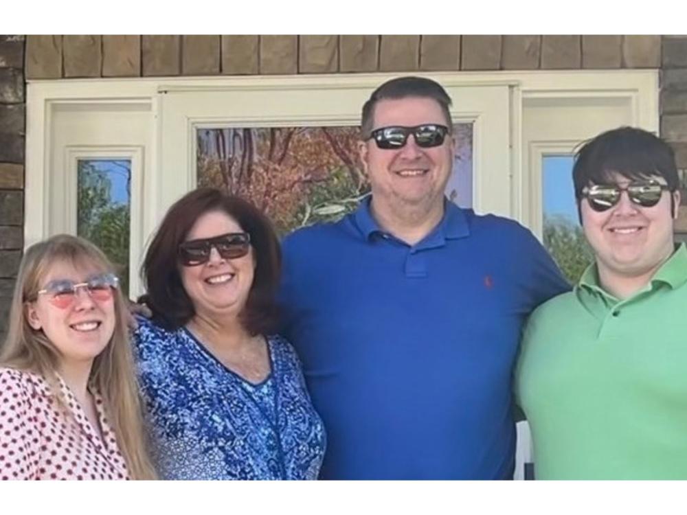 daughter, mother, father, and son with front door in background