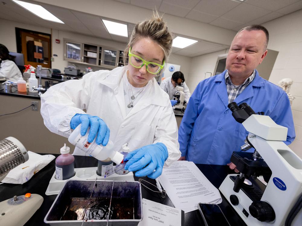 Student and faculty member in a lab