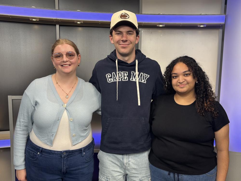 Three students side by side in a light blue sweater, Penn State hoodie and black shirt.