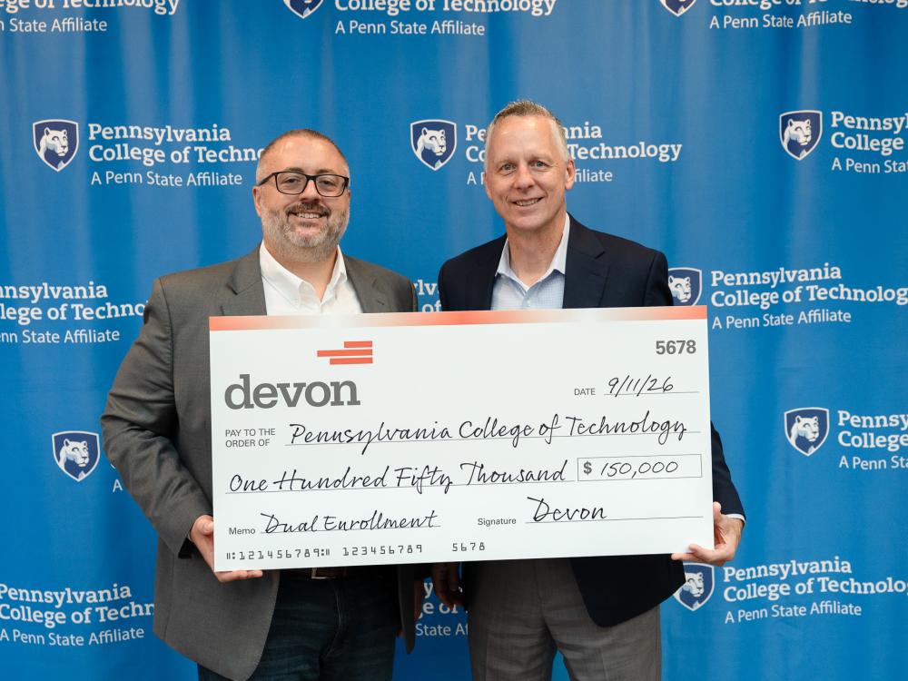 Two men hold up a very large check.