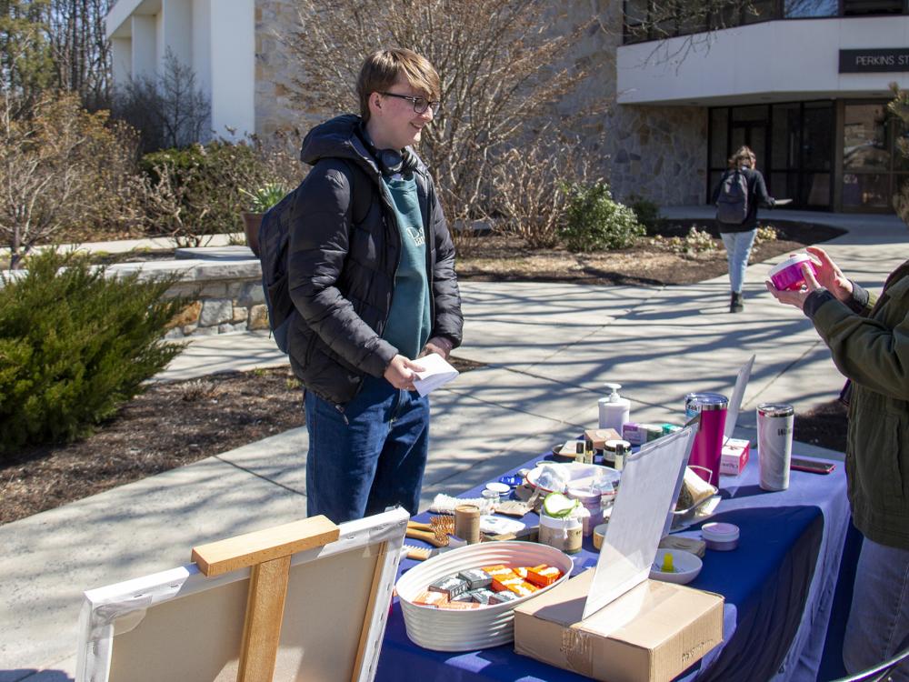 A smiling student talks about hygiene products made of sustainable materials with counselor
