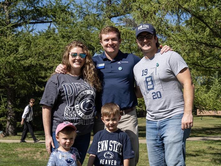 Three adults and two children wearing Penn State gear pose for a photo