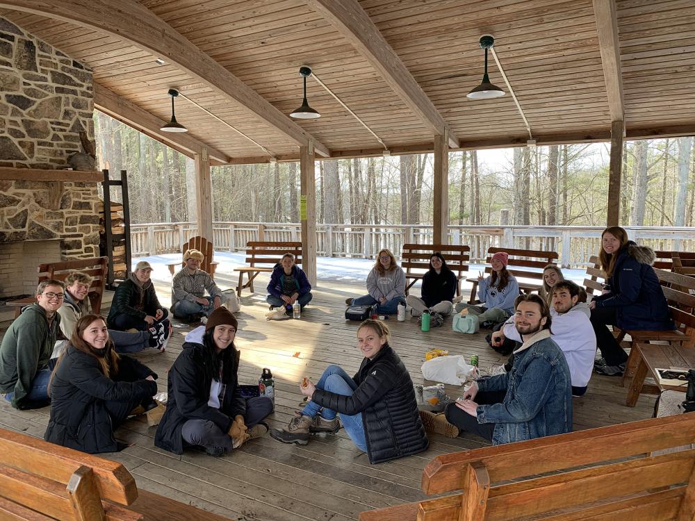 Students sitting in a circle inside a cabin