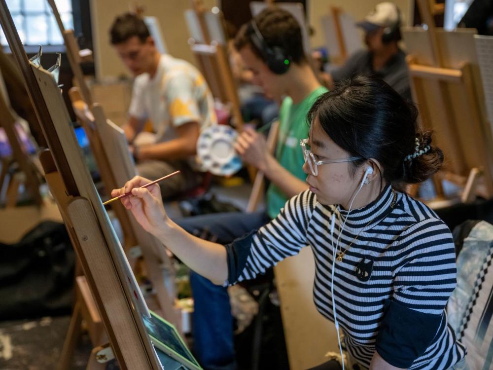 A student paints in an art class at Penn State Behrend