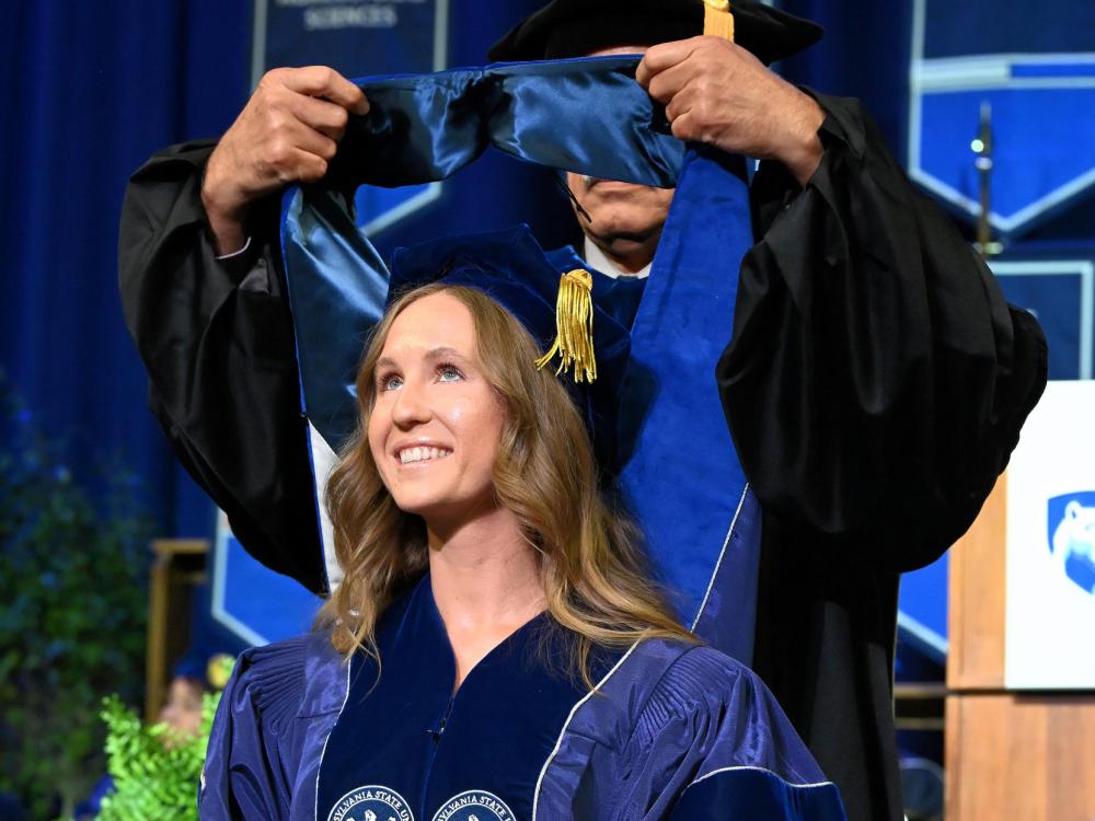Trisha Campanaro is hooded during her Penn State graduation ceremony
