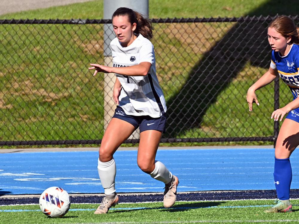 Penn State Altoona soccer player Kira Trexler controls the ball during a game as an opposing player defends.