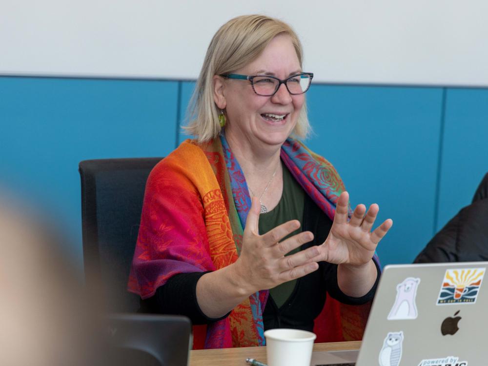Jennifer Van Hook wears a multi-colored scarf and makes a point at an event.