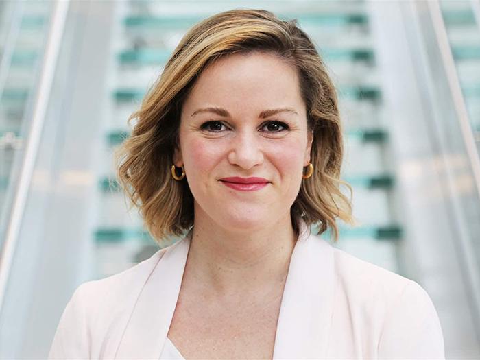 Person with short blonde hair wearing white.