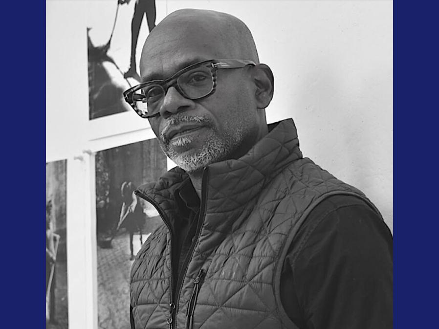Black man with dark glasses smiling