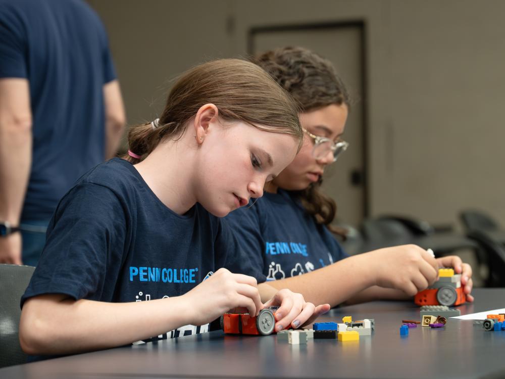 Students at a table, working with architectural blocks