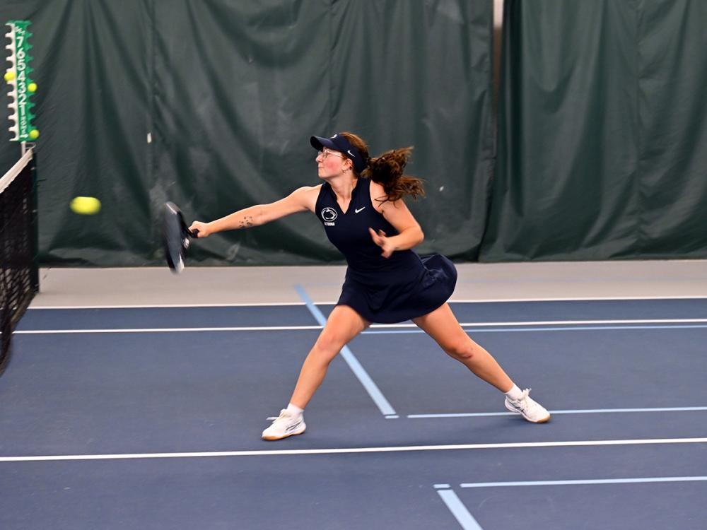 Caitlin Blessel lunges to return a tennis ball during a match.