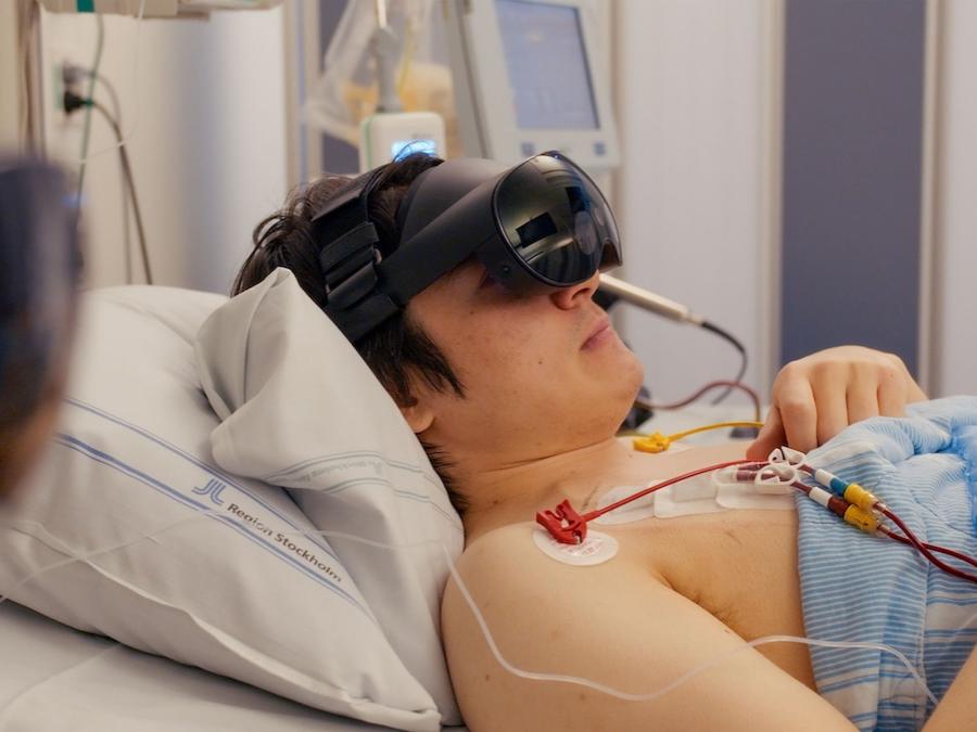 a person in a hospital bed uses a virtual reality headset
