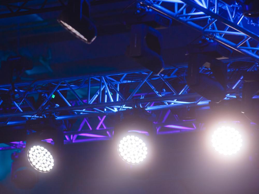 Lights shine down in a theater setting