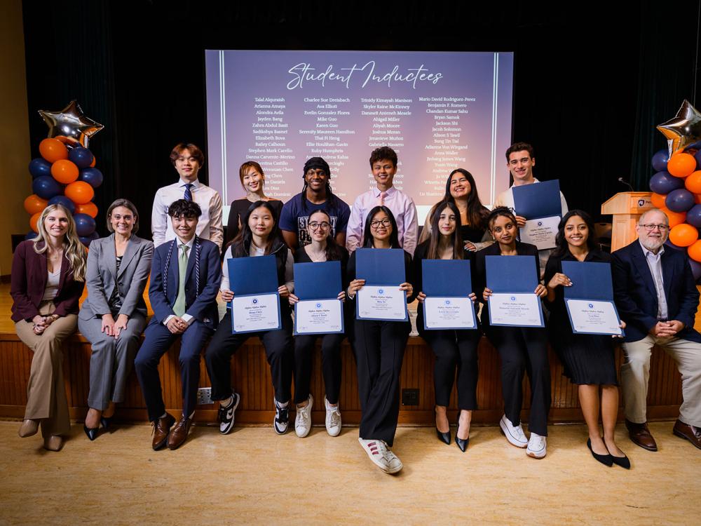 Honor society inductees holding certificates