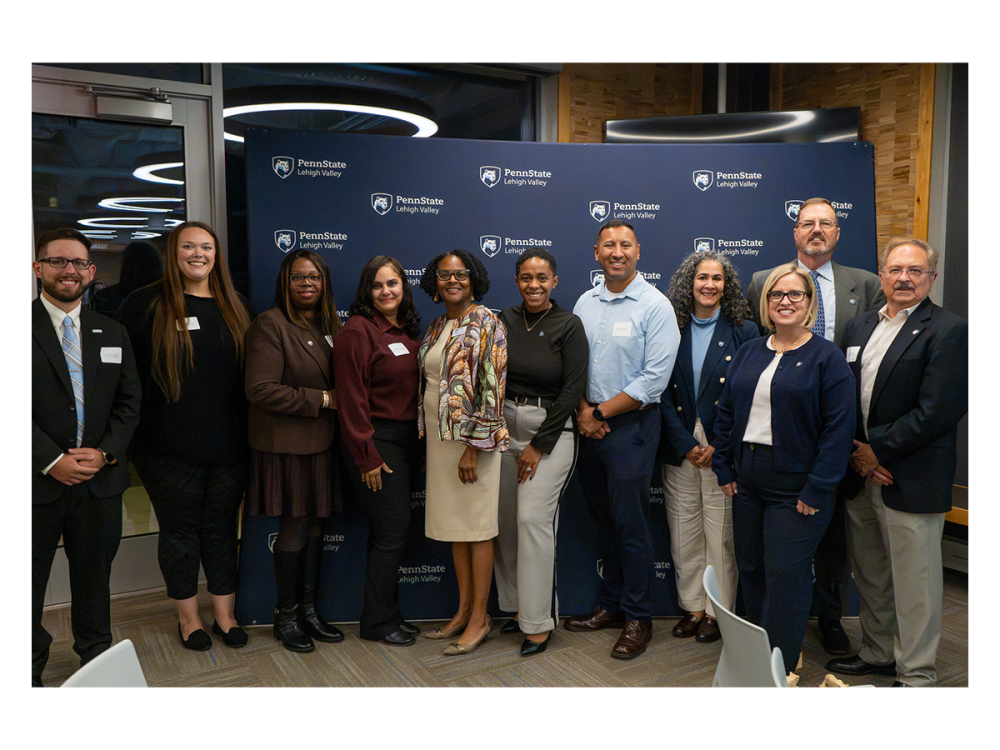 group of people standing in front of a penn state lehigh valley backdrop