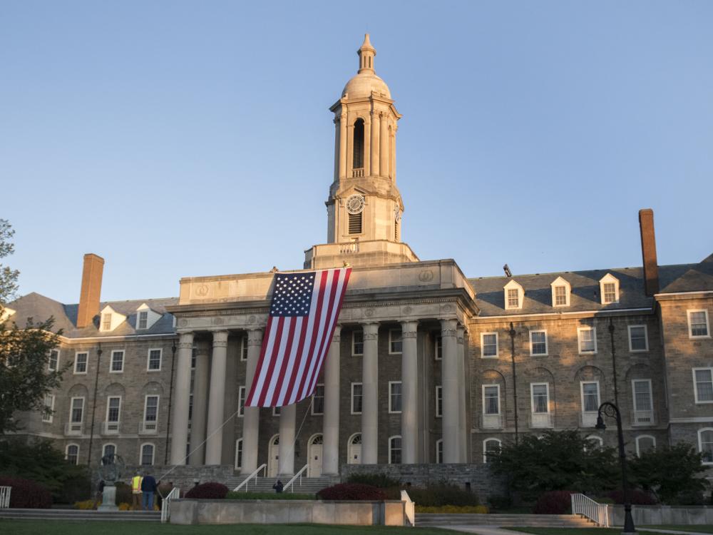 wide shot old main with flag