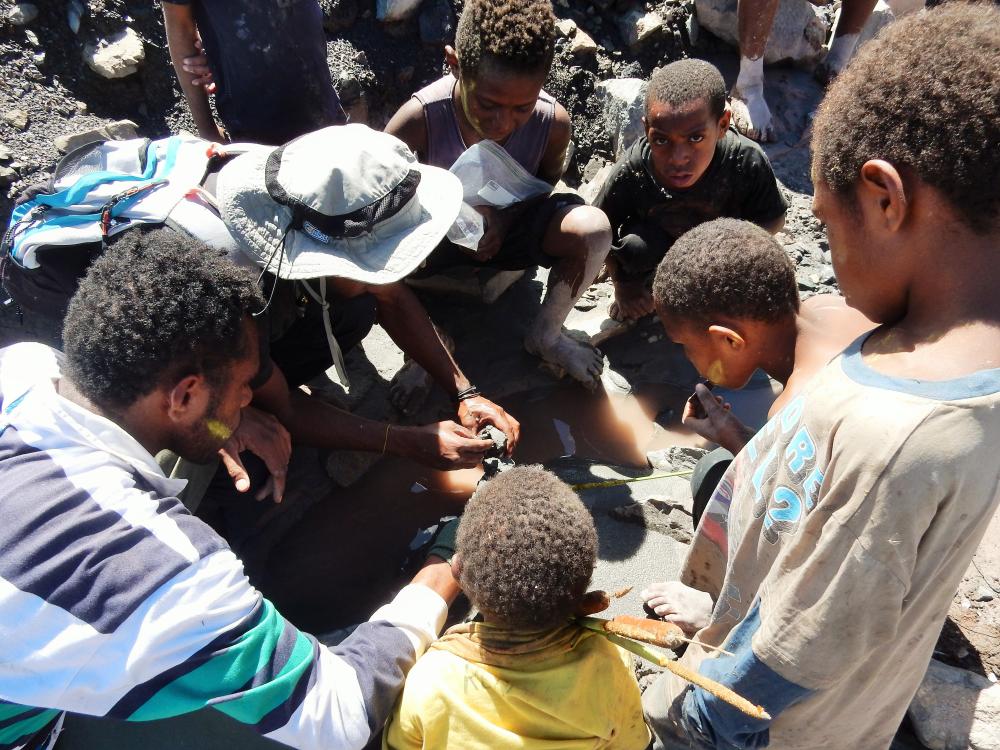 Children watch as a water sample is collected near their village in remote Papua New Guinea as part of study including Penn State researchers. 