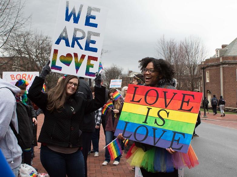 students holding signs depicting messages about love