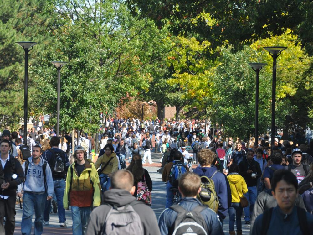 Students outside of Old Main along Pollock Road at University Park. 