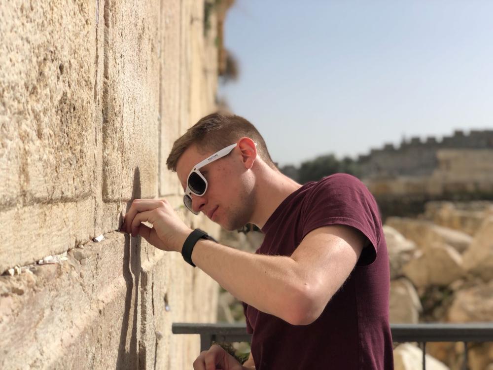 Ben Cutler puts a note in the Western Wall in Jerusalem.