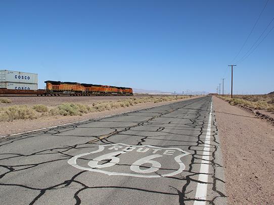 photo of US Route 66 with railroad in the background