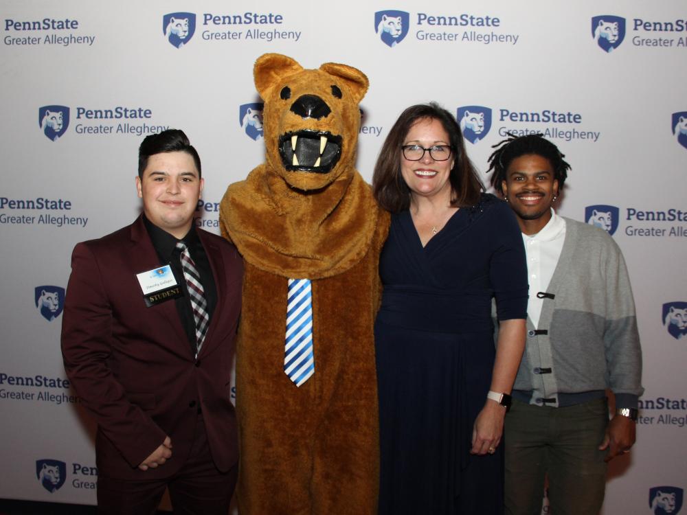 Lion mascot with students and Greater Allegheny chancellor 