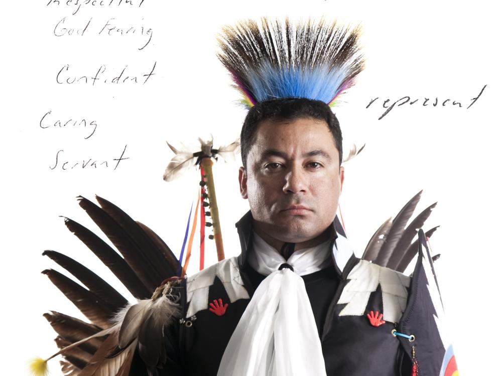 American Indian in regalia with text written behind