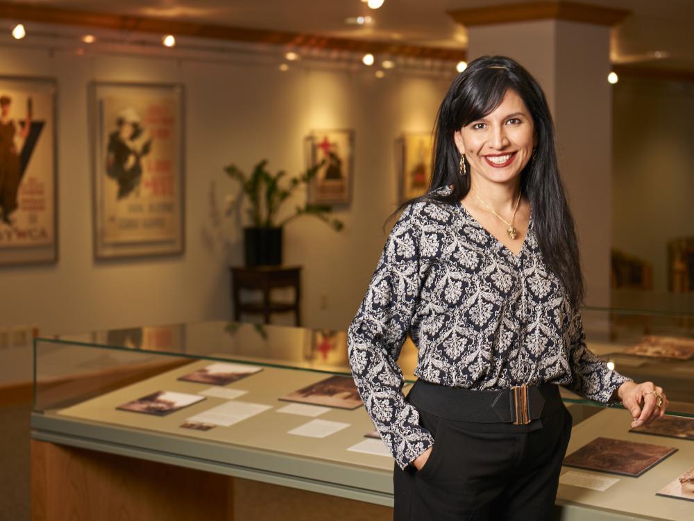 image of woman standing in front of glass-topped exhibit cases in library exhibition room of rare and special collections