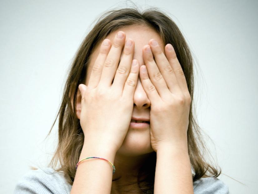 Child covering face with hands