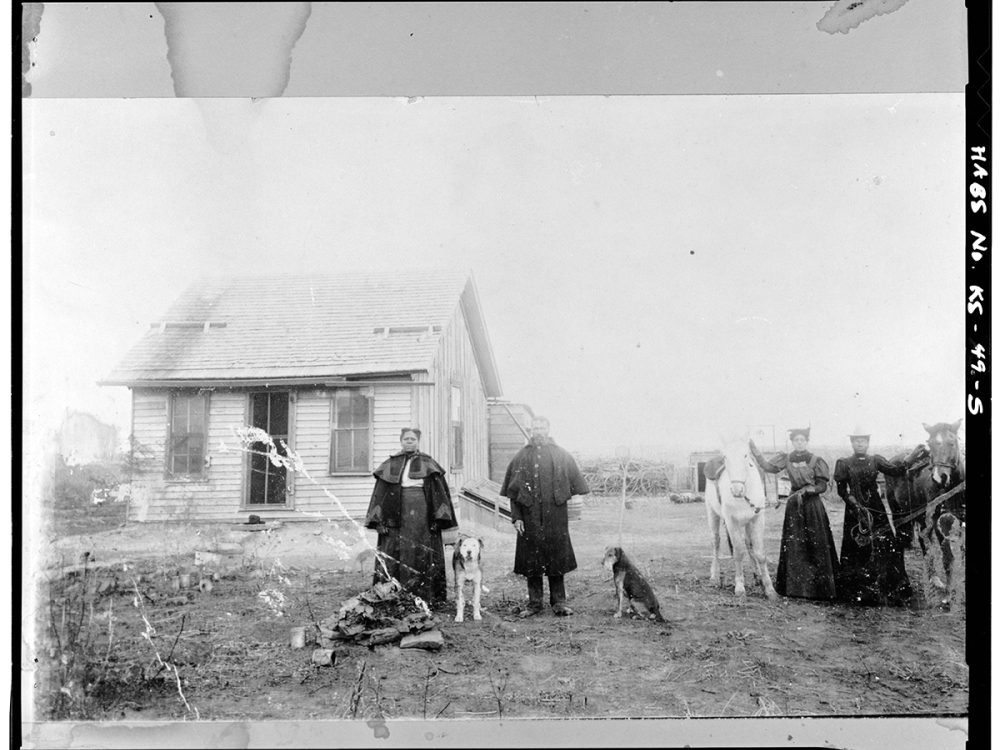 African Americans who migrated from States along the Mississippi River to Kansas in the late 19th century following the Civil War, in front of a home in Nicodemus, Kansas. 