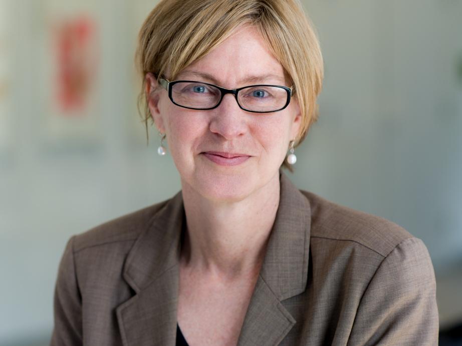 Susan Short headshot in tan sweater and glasses