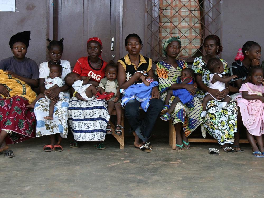 Women and children seated in a row, waiting to see a doctor