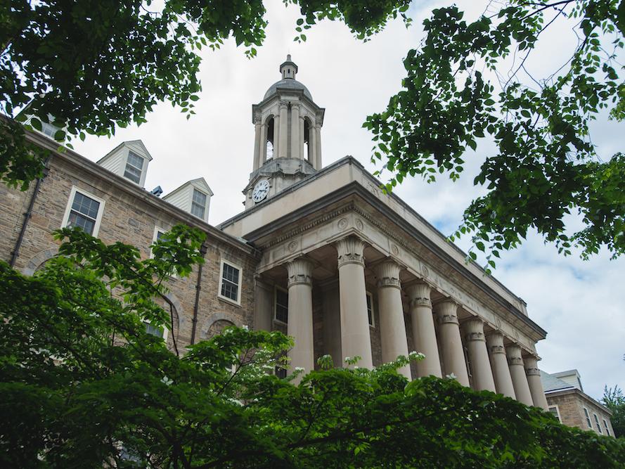 Photograph of Old Main surrounded by summer foliage