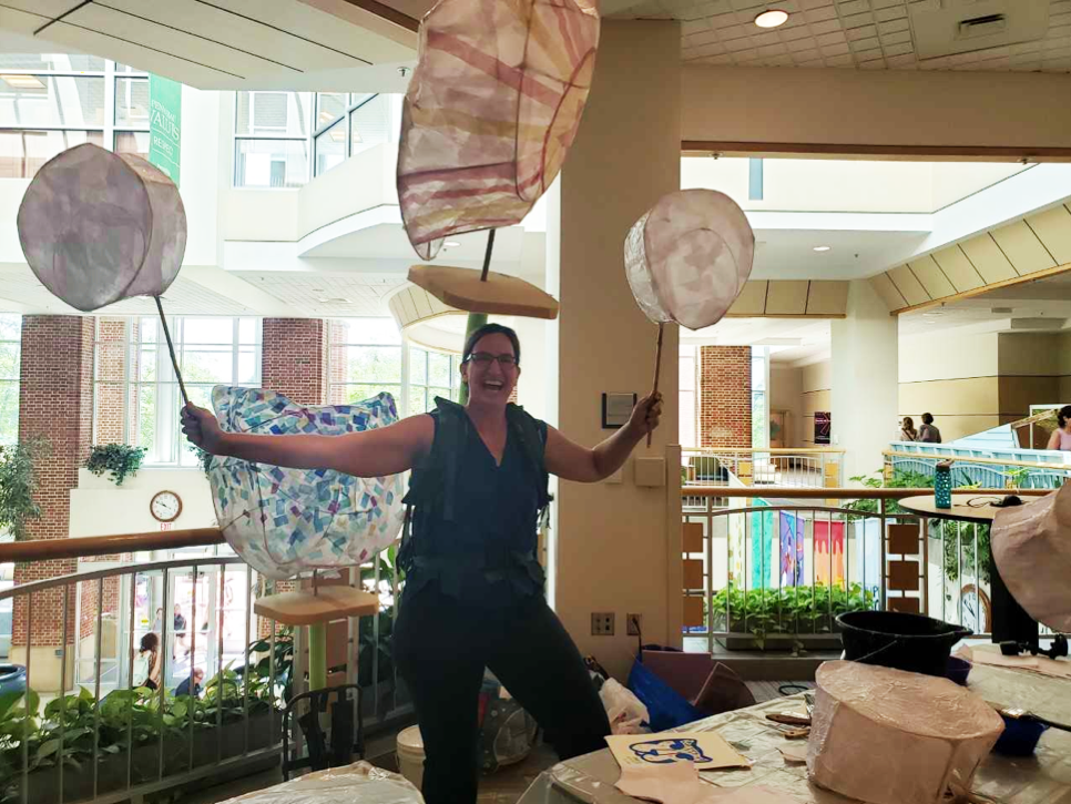 Capezzuti demonstrating how her puppets would look at the parade, only without the linen cloth.