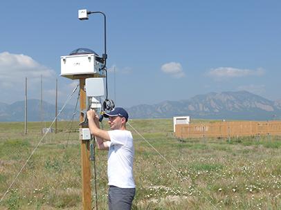 Guido Cervone makes adjustments to one of the National Center for Atmospheric Research’s total sky imagine machines.