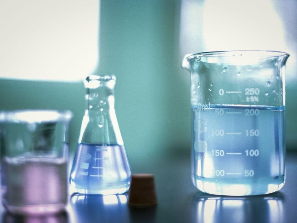 Three different chemistry beakers sitting on a table