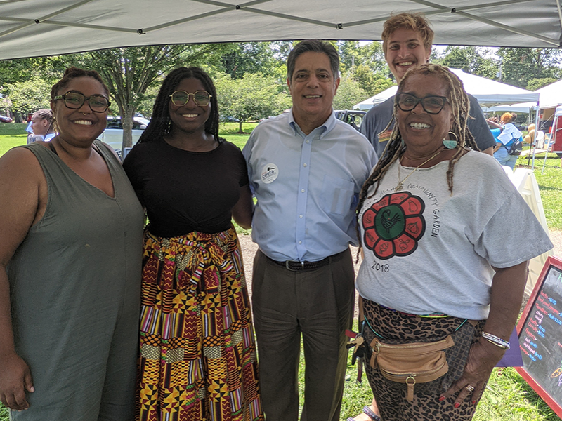 Group of five people photographed in front of a garden at Sankofa Village Community Garden.