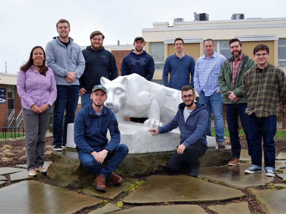 Penn State New Kensington BET students and faculty member stand by lion statue